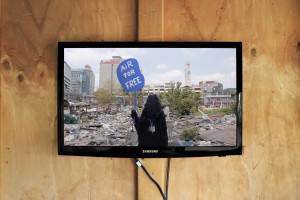 video display. figure holding sign marked Air For Free.