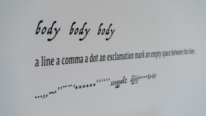 text on wall: body body body / a line a comma a dot an exclamation....(continues)