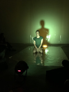 performance, wearing green, bathed in eery light