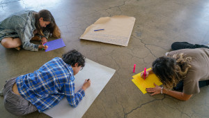 3 people writing on craft paper