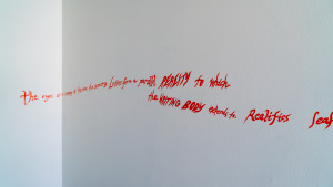 Red text hand drawn on white walls